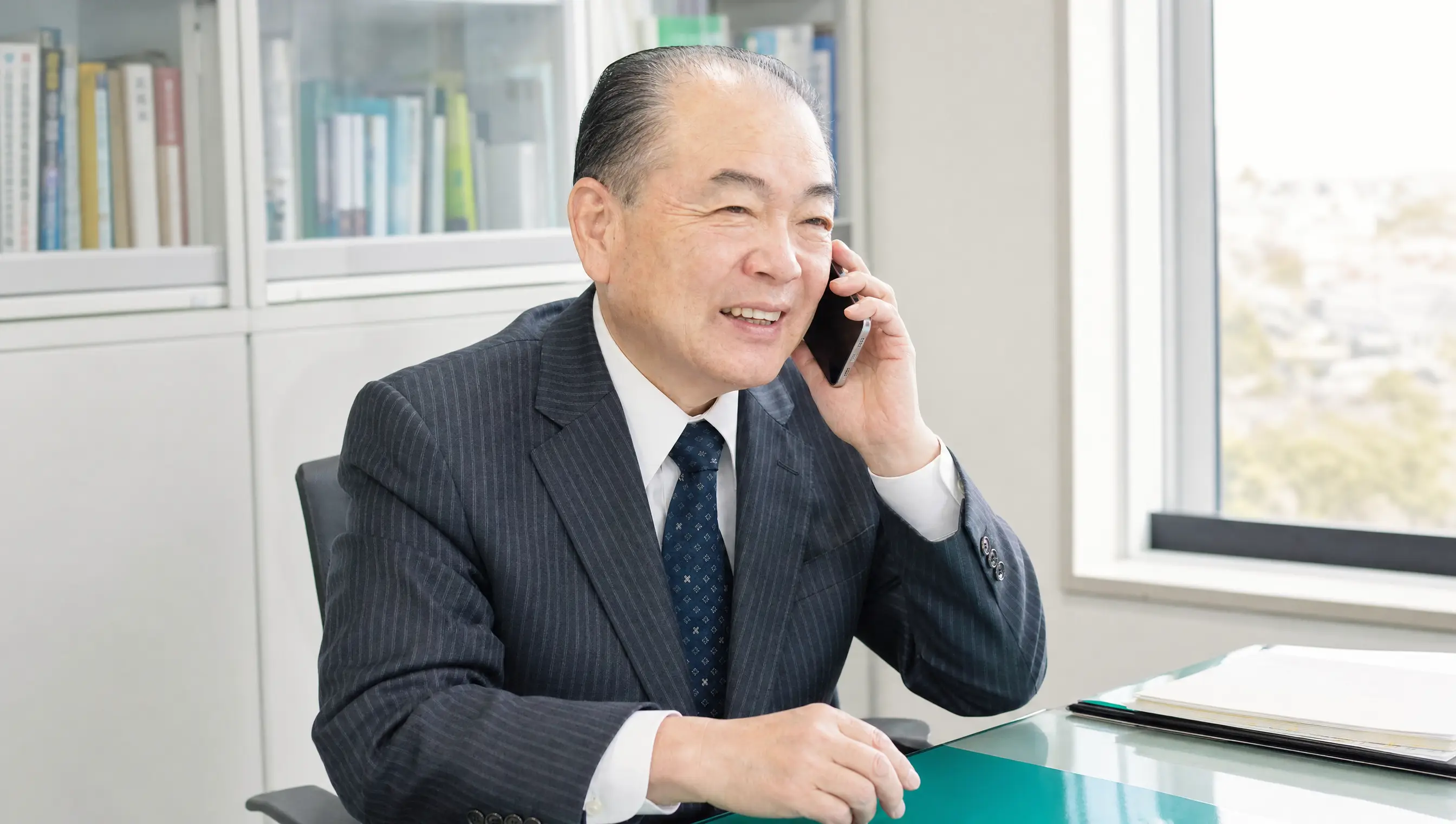 村山正憲氏が電話で話す場面を描いたAI生成イメージ